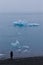 Girl watching bizarre ice floes of Iceberg lagoon jokulsarlon on the south of Iceland