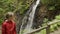 Girl watching mountain waterfall