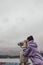 A girl watching through stationary binoculars on the pier for passing ships and wildlife on the seashore