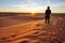 Girl watching the sunrise on the sand dune in the Sahara desert