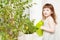 Girl watering basil in a pot on the windowsill