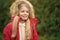 Girl wear furry cape enjoy fall nature park. Hide above cozy hood or cape. Child blonde long hair walking warm jacket