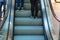 Girl wear sneaker riding on an escalator. feet standing on escalator