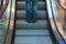 Girl wear sneaker riding on an escalator. feet standing on escalator