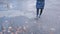 Girl wearing black combat boots splashing in a puddle after rain