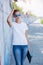 Girl wearing blank white t-shirt, jeans posing against rough street wall