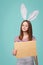 Girl wearing bunny ears holding a blank letter envelope