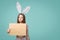 Girl wearing bunny ears holding a blank letter envelope