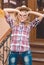 Girl wearing cowboy hat making glasses by hands in