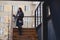 A girl wearing eyeglasses in winter wears wooden stairs