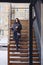 A girl wearing eyeglasses in winter wears wooden stairs