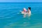 Girl is wearing inflatable armbands, learning to swim in the sea