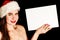 Girl wearing Santa hat and holding blank sheet of paper