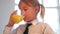 Girl Wearing School Uniform Drinking Glass Of Orange Juice