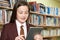 Girl Wearing School Uniform Using Digital Tablet In Library