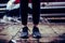 Girl wearing sneakers standing on the wet asphalt. Ambulance car and splashing puddle on the background