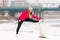 Girl wearing sport uniform stretching on snow