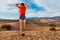 Girl wears rucksack, stands with Death valley view