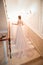 A girl in a wedding dress is walking up the stairs. beige dress. Beautiful lady in luxurious ballroom dress walking up the stairs