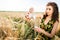 Girl in wheat field. Girl pours milk into a glass