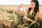 Girl in wheat field. Girl pours milk into a glass