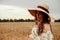 Girl wheat field summer. Happy young woman in sun hat in summer wheat field at sunset. Nature, summer holidays, vacation