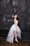 Girl in a white ball gown and shoes, beautiful red hair. Young theater actress. Little prima ballet. Young ballerina girl