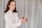 A girl with a white blouse holds essential oils in her hands and drips on her wrist