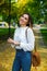 Girl in a white blouse and jeans posing on street in spring. Happiness and relax concept.