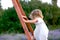 Girl in a white dress climbs a wooden staircase in nature