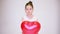 A girl in a white dress and with a heart-shaped balloon looks at the camera and smiles. Slow Motion Video