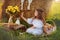 The girl in a white dress sits on the grass near the haystack in the summer