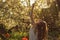 Girl in white dress sitting among flowers and fluff with threw back her head near tulips in sunset, dandelions and cherry flowers