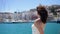 Girl in white dress stay along berth and beach, boats background, Ibiza
