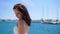 Girl in white dress walk along berth and beach, boats background, Ibiza