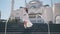 a girl in a white dress is walking by the white mosque