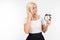 Girl in white hair sets the alarm clock for morning in the hand on an isolated white background