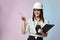 The girl in the white helmet points the direction with her hand. the concept of a businesswoman who understands construction,