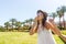 A girl in a white long dress is walking on a tropical palm sends an air kiss to the camera