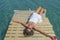 Girl in white lying on the dock holding a heart in her hand