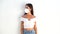 Girl in a white mask N- 95 on the background of a white wall. A young girl wearing a white shirt