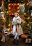 A girl in a white scarf with a gift in a Christmas gazebo in the Scandinavian style