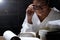 Girl in white shirt reading many textbooks on table with many hi