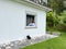 a girl in a white shirt a teenager sits on a white windowsill the view from the street she can be seen in the window in