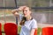 A girl in a white T-shirt and black leggings sits on red chairs for the fans feeling unwell and measures the temperature of her