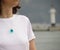 Girl in a white t-short with a turquoise pendant of epoxy resin. Handmade jewelry. Lighthouse background