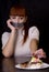 The girl, whose mouth sealed with tape sad looking at plate with