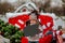 Girl in winter bull hat posing with name empty plate standing in Christmas car