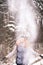 Girl in winter clothes throwing snow up in air