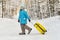 A girl in winter in felt boots goes with a suitcase on a frosty snowy day